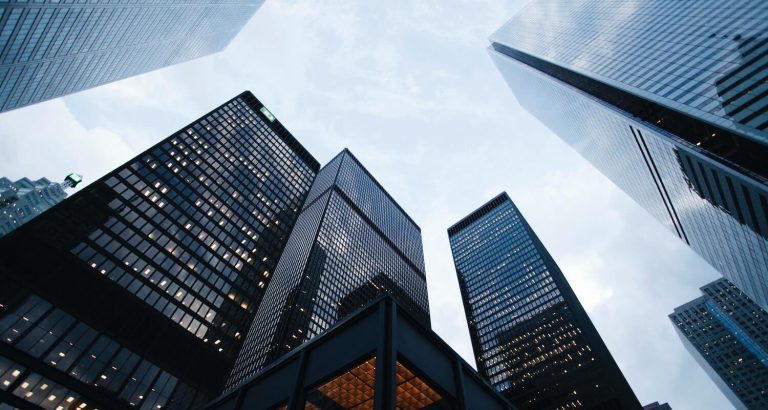 Billede af skyskrabere overfor hinanden, der symboliserer benchmark af finansielle afkast.
